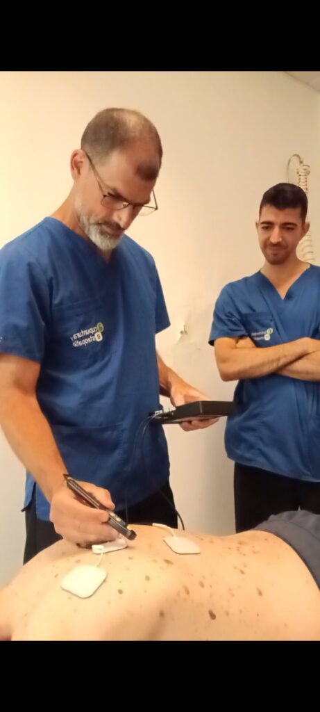 Fisioterapeuta aplicando una técnica de fisioterapia invasiva durante un tratamiento en FiO Sabadel